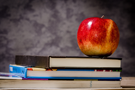 A photo of an apple on top of a stack of books